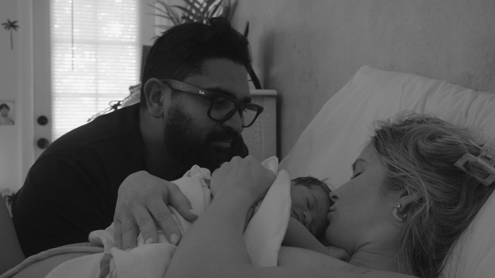 A family snuggling their newborn during the first feed